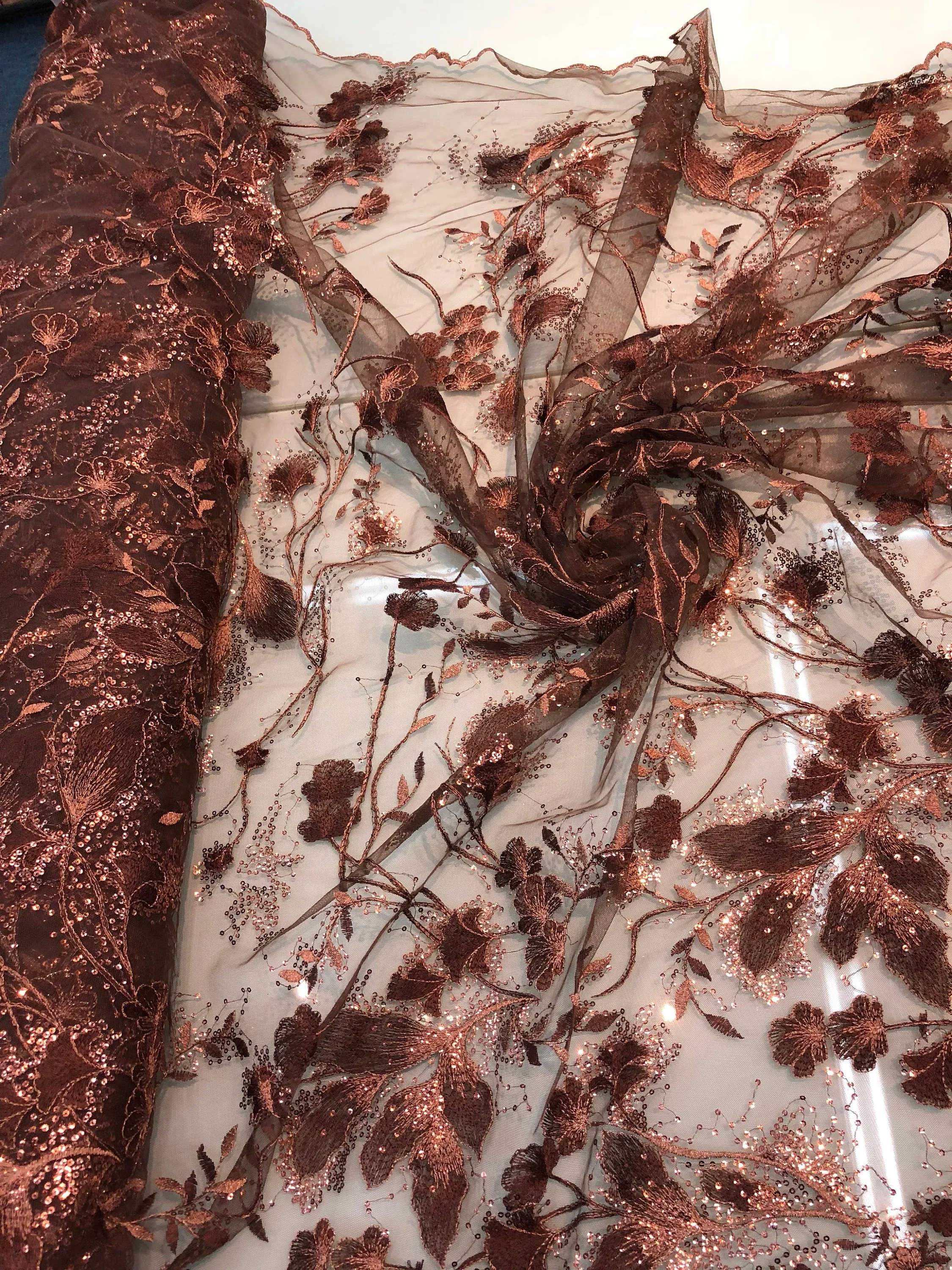 Floral thread embroidered with sequins embroidered on top of it on meah fabric sold by the yard